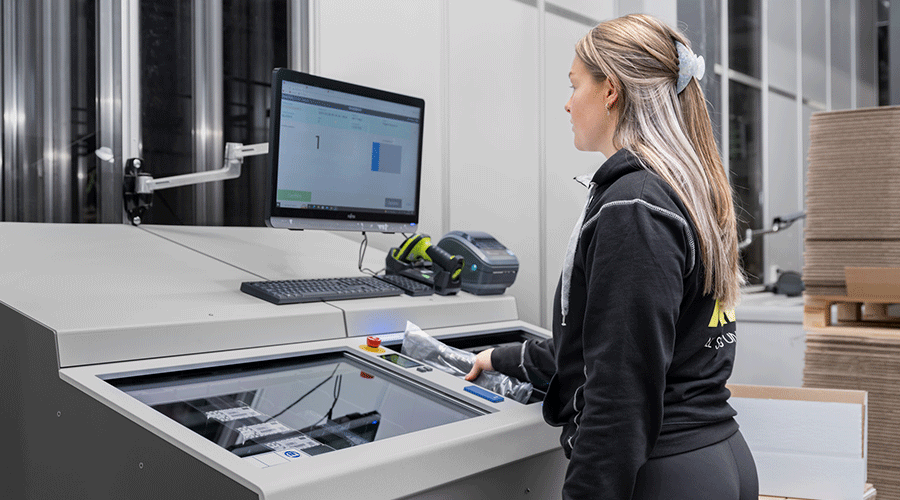 An XXL employee using the AutoStore FusionPort workstation