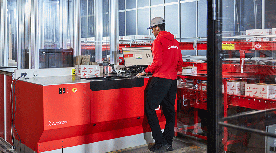 A warehouse worker uses the AutoStore CarouselPort.