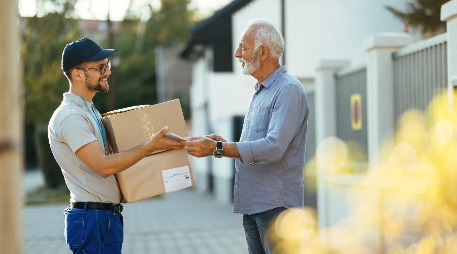 A happy customer receiving his parcel from happy delivery personell