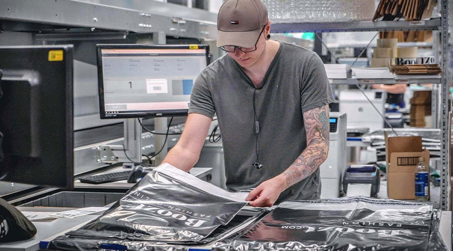 Man picking products at Boozt retail warehouse. Image