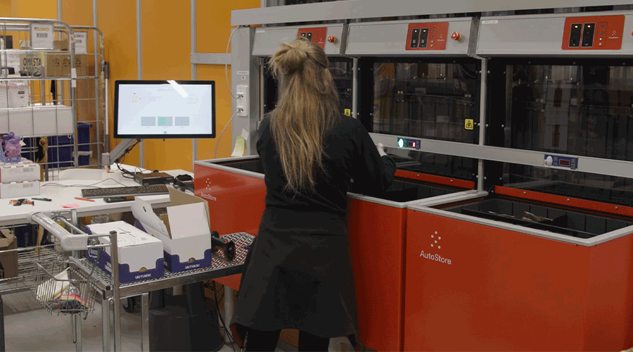 Woman replenishing inventory into AutoStore ConveyorPort at Kesko in Finland. Image.