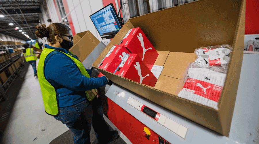 A woman picking items from an AutoStore. Image.