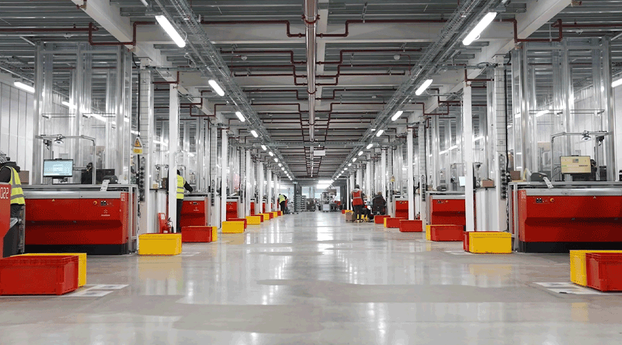 Workers picking goods from AutoStore Ports at THG warehouse in England. Image.