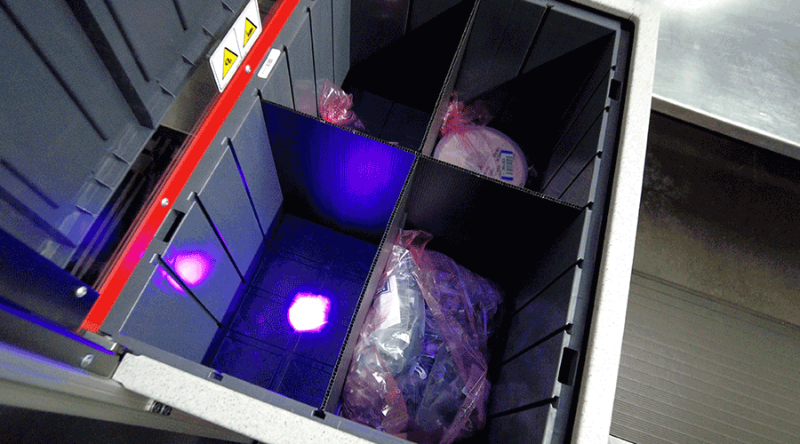 Pick-to-light system illuminating products within AutoStore workstation. Image.