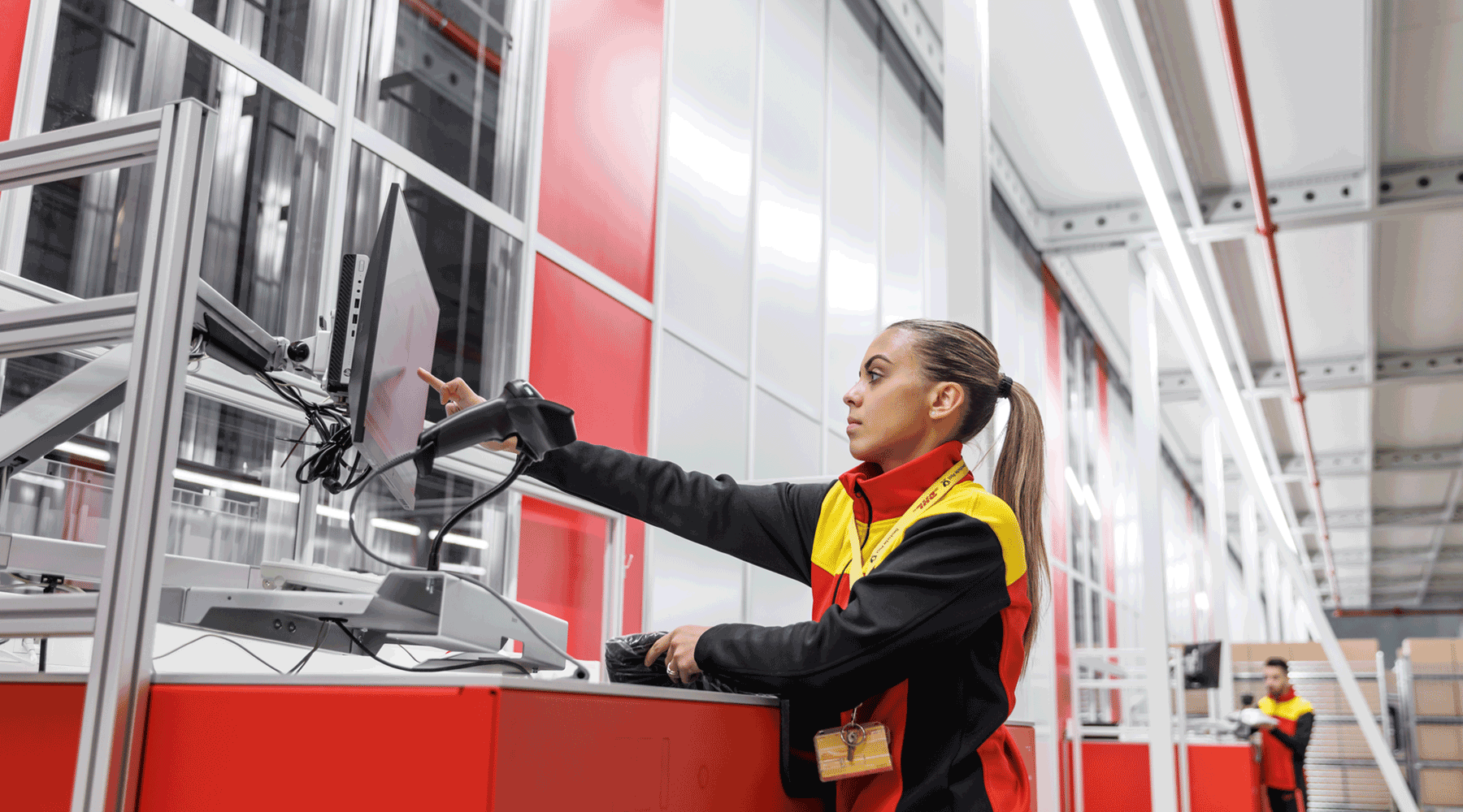 DHL employee fulfilling an order from an AutoStore workstation. Image