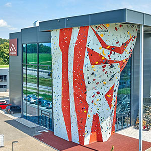 Exterior of an eXXpozed retail location showing a rock-climbing wall. Image
