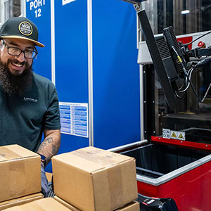 Polaris employee fulfilling a customer order from an AutoStore system workstation. Image.